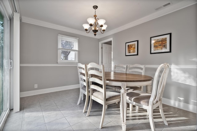 dining space featuring ornamental molding, light tile patterned floors, and an inviting chandelier