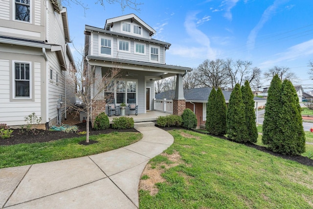 view of front facade with ceiling fan, a front lawn, and covered porch