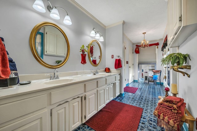 bathroom with a textured ceiling, vanity, an inviting chandelier, and crown molding