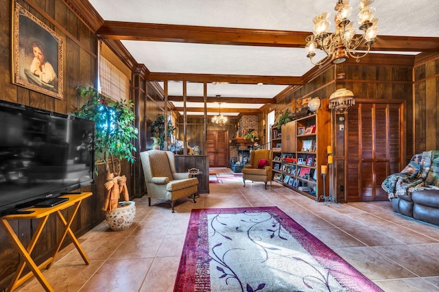 tiled living room featuring beam ceiling, wooden walls, a textured ceiling, and an inviting chandelier