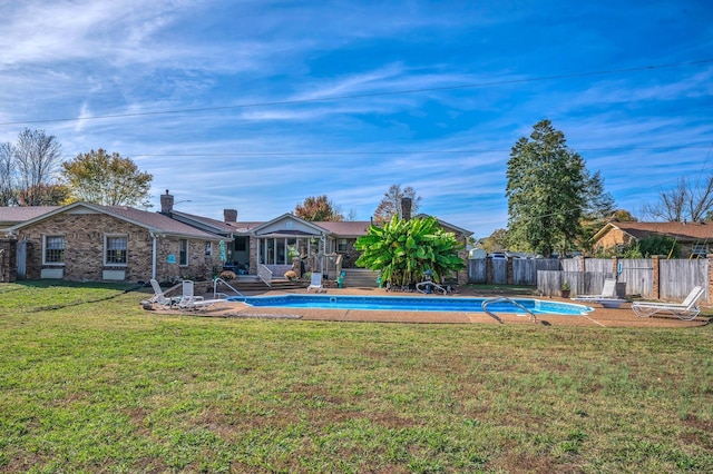 view of swimming pool with a lawn