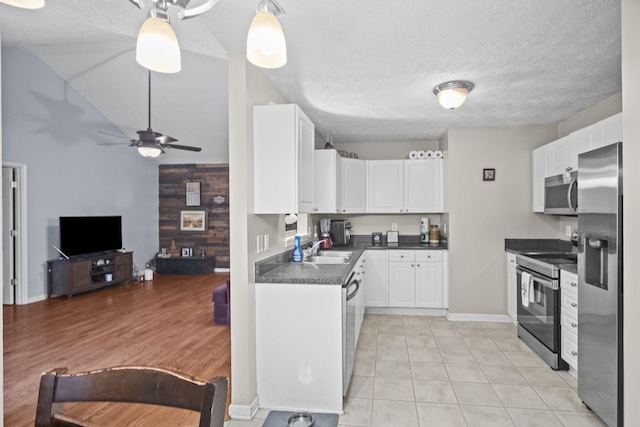 kitchen featuring white cabinets, sink, light tile patterned floors, a textured ceiling, and stainless steel appliances