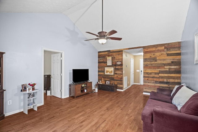 living room with wooden walls, hardwood / wood-style floors, and lofted ceiling