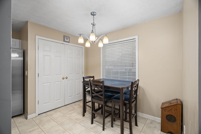 tiled dining room with a textured ceiling and an inviting chandelier