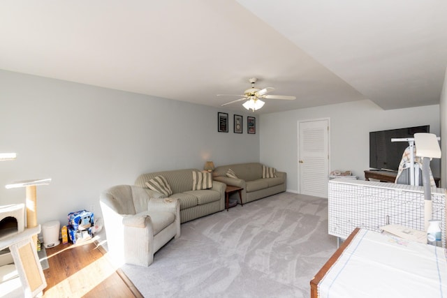 carpeted living room with ceiling fan