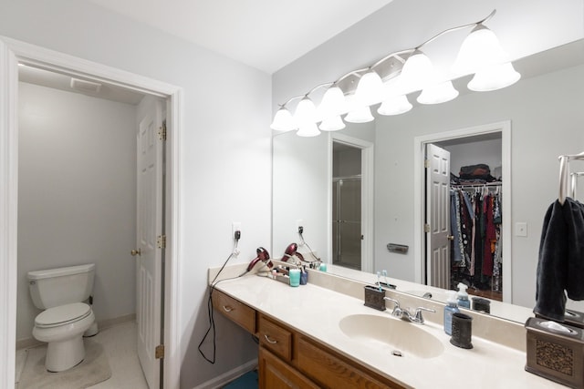 bathroom with tile patterned floors, vanity, toilet, and a shower with door