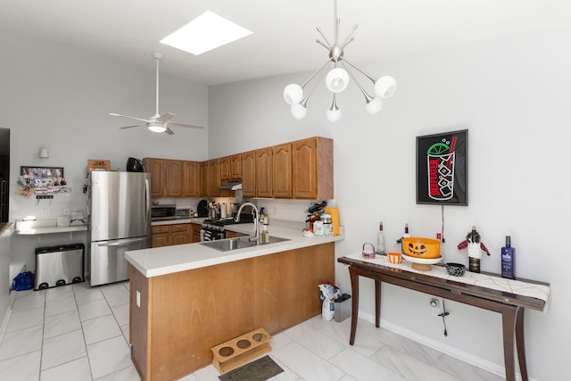 kitchen featuring stainless steel appliances, tasteful backsplash, high vaulted ceiling, kitchen peninsula, and decorative light fixtures