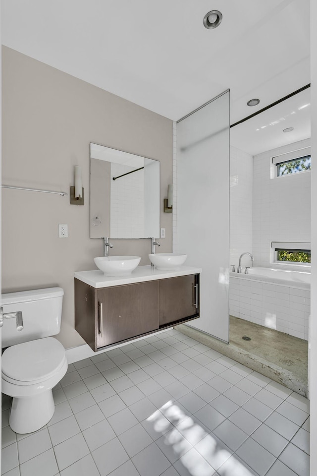 bathroom featuring toilet, a washtub, vanity, and tile patterned flooring