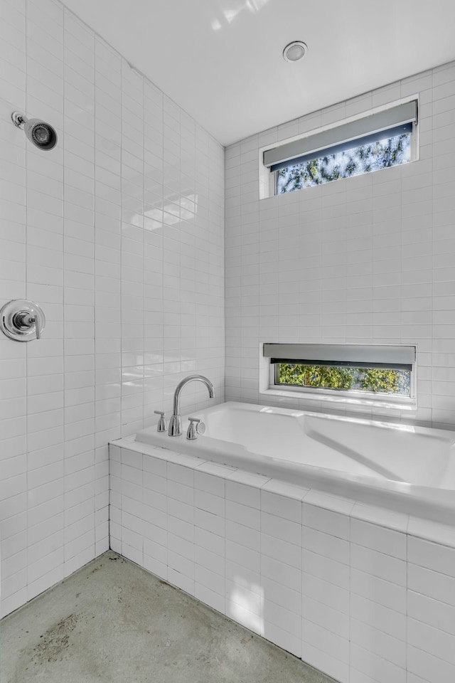 bathroom with tile walls and tiled bath