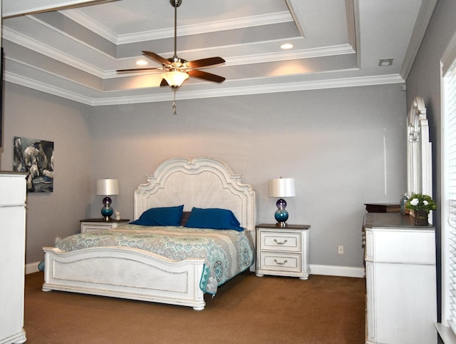 bedroom featuring dark colored carpet, a tray ceiling, ceiling fan, and ornamental molding