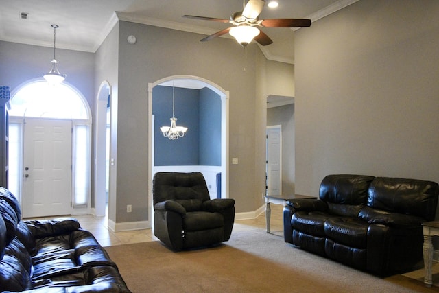 tiled living room with ceiling fan with notable chandelier and crown molding