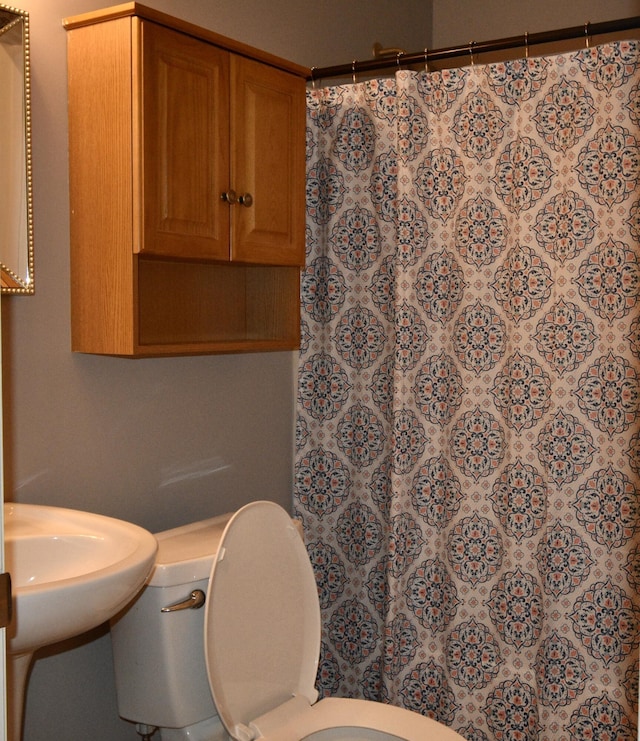 bathroom with curtained shower and toilet