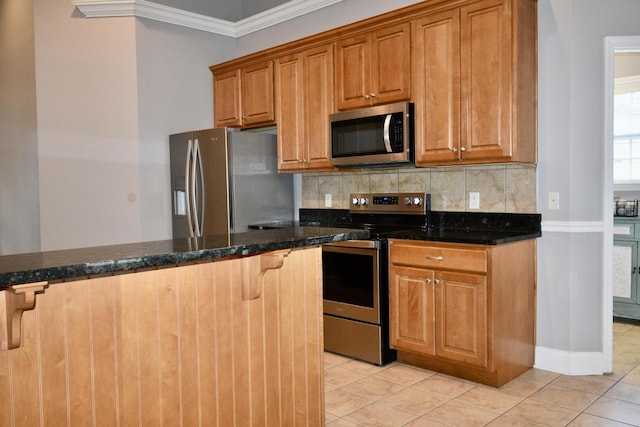 kitchen with light tile patterned floors, stainless steel appliances, ornamental molding, and dark stone counters