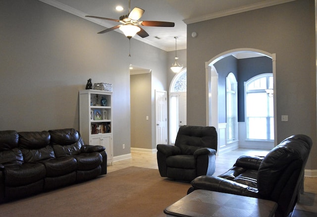 living room with ceiling fan, crown molding, and light carpet