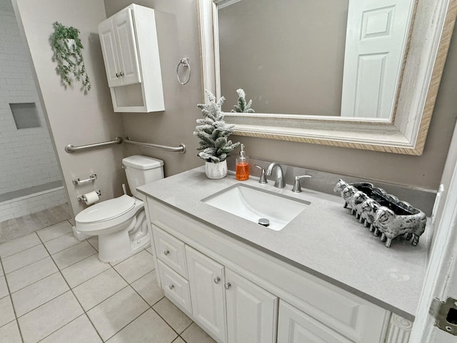 bathroom featuring tile patterned flooring, a tile shower, vanity, and toilet