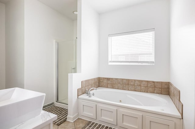 bathroom with tile patterned floors, sink, and plus walk in shower