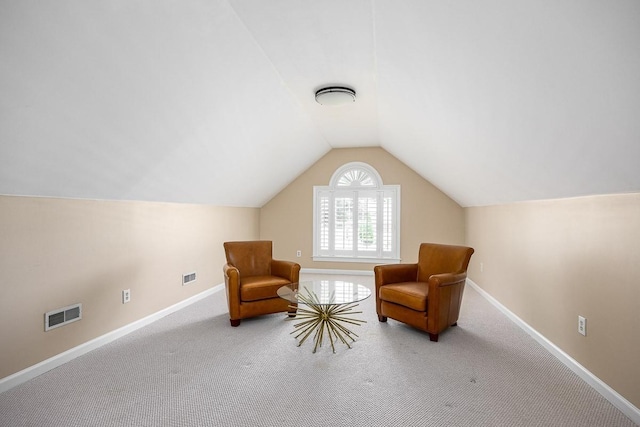 living area featuring carpet and vaulted ceiling