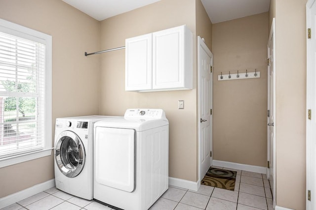 clothes washing area featuring cabinets, light tile patterned floors, and separate washer and dryer