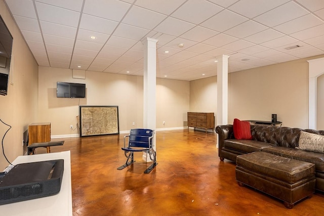 living room featuring a paneled ceiling and concrete flooring