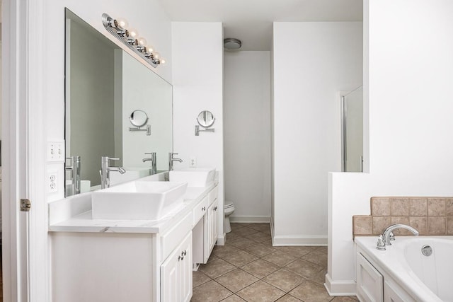 bathroom with tile patterned flooring, vanity, toilet, and a washtub