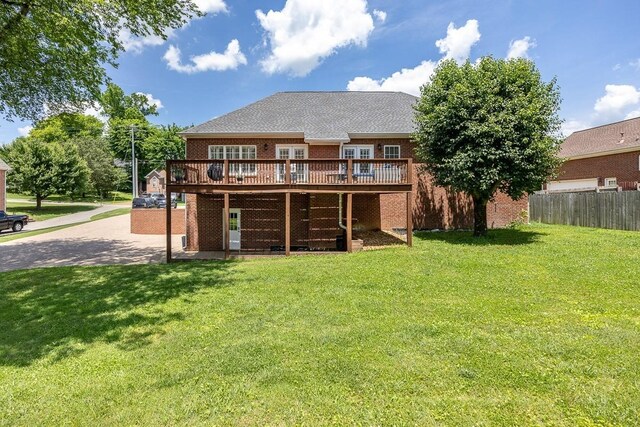 rear view of property featuring a wooden deck and a yard