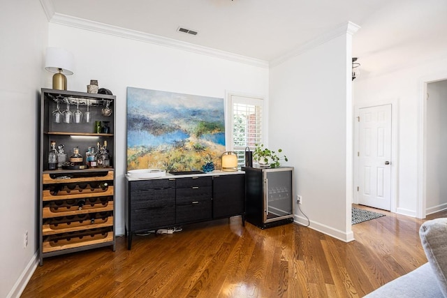 bar with dark hardwood / wood-style flooring, ornamental molding, and wine cooler