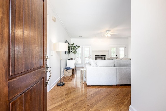 unfurnished living room with french doors, light hardwood / wood-style flooring, ceiling fan, and ornamental molding