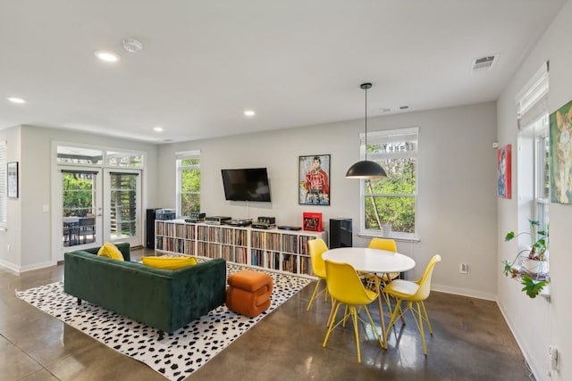 living room featuring french doors and concrete floors