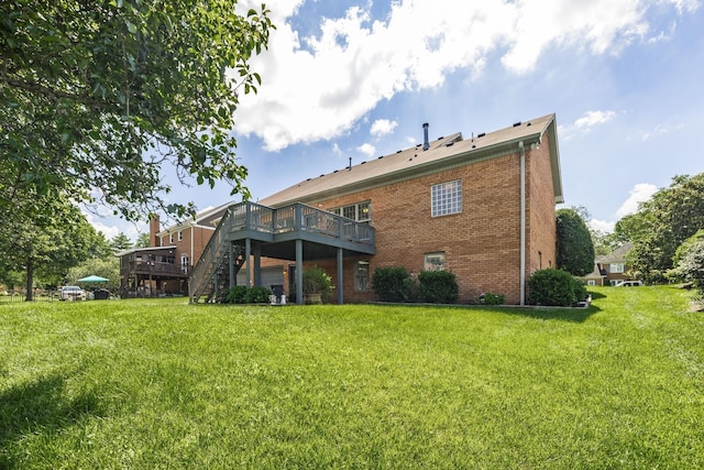 back of house featuring a deck and a lawn