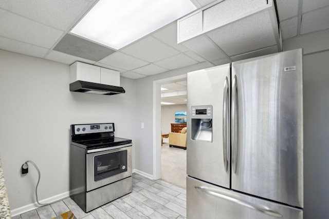 kitchen featuring stainless steel appliances, white cabinets, a paneled ceiling, and exhaust hood