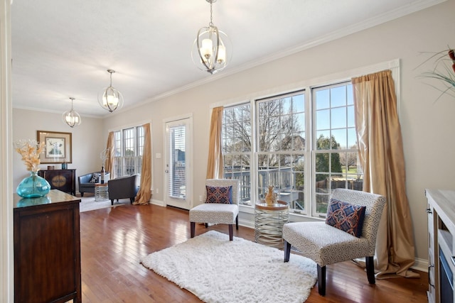 sitting room with a chandelier, ornamental molding, and dark wood-type flooring