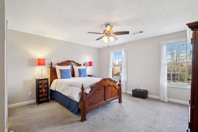 bedroom with multiple windows, light carpet, and ceiling fan