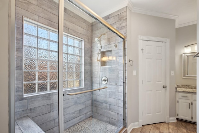 bathroom with ornamental molding, vanity, and a shower with shower door