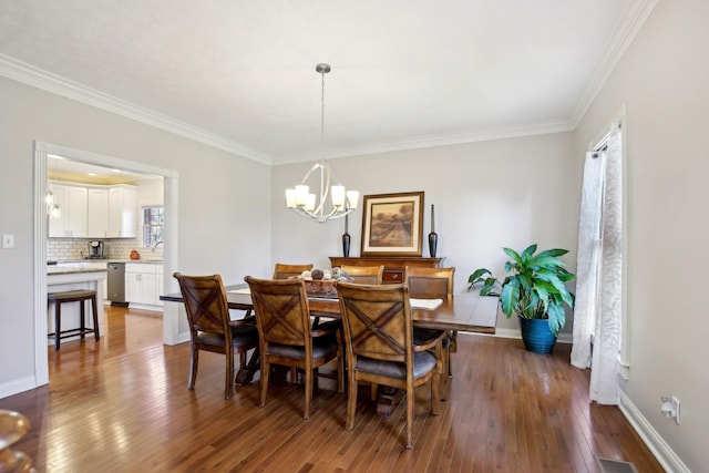 dining room featuring ornamental molding, dark wood-type flooring, an inviting chandelier, and a wealth of natural light