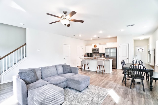 living room featuring ceiling fan and light hardwood / wood-style floors