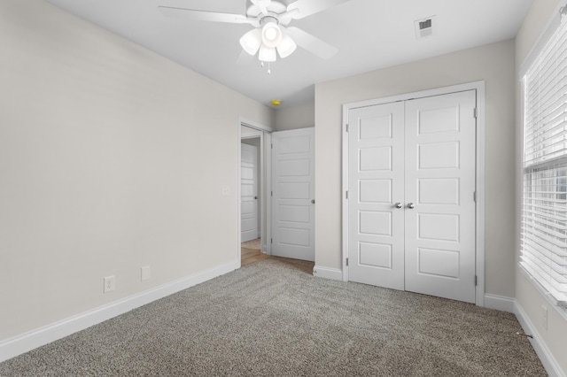 unfurnished bedroom featuring carpet flooring, a closet, and ceiling fan