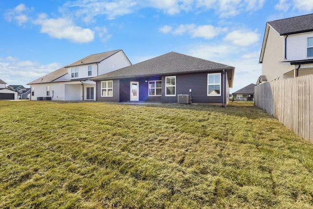 rear view of property with central air condition unit, a yard, and a patio area