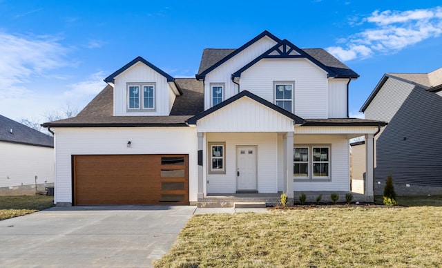 view of front of home with a front lawn, central AC unit, a porch, and a garage