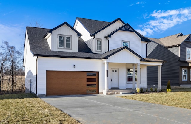 view of front of property featuring a garage, a front yard, and covered porch