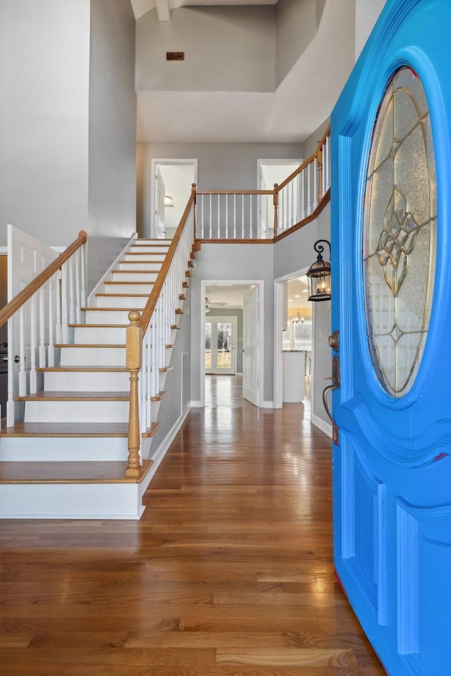 foyer entrance with hardwood / wood-style floors and a high ceiling