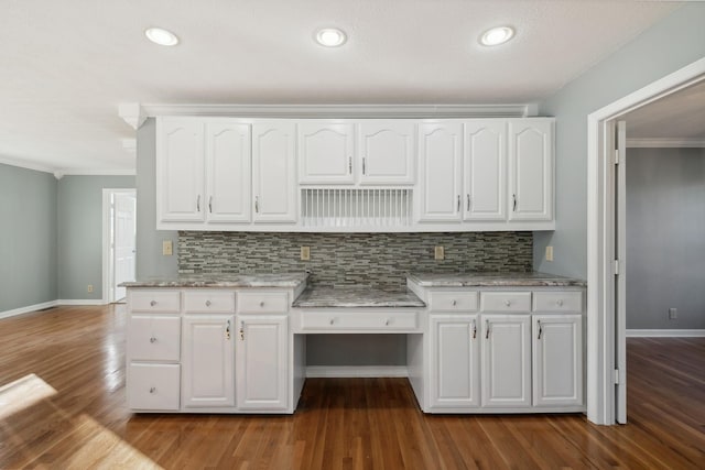 kitchen with white cabinets, ornamental molding, backsplash, and hardwood / wood-style flooring