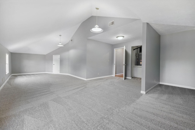 carpeted empty room featuring lofted ceiling