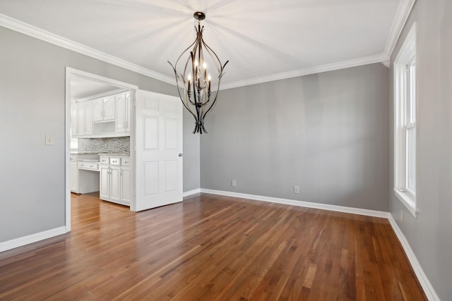 unfurnished dining area with wood-type flooring, an inviting chandelier, a wealth of natural light, and ornamental molding