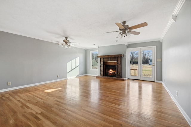 unfurnished living room with crown molding, a fireplace, ceiling fan, and light hardwood / wood-style flooring