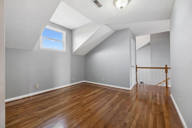 bonus room with dark wood-type flooring and lofted ceiling