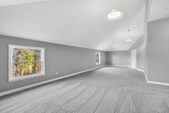 spare room featuring carpet, vaulted ceiling, and a wealth of natural light