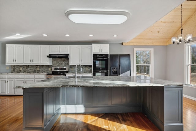 kitchen featuring white cabinetry, light stone countertops, tasteful backsplash, and black appliances