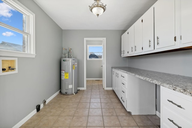 laundry area with washer hookup, light tile patterned flooring, cabinets, and water heater