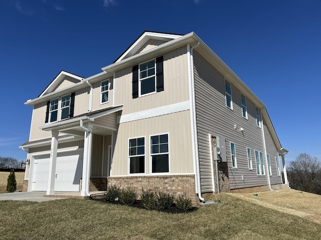 view of front facade featuring a front lawn, concrete driveway, brick siding, and an attached garage