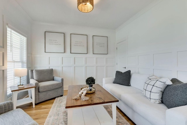 living room with light hardwood / wood-style floors and ornamental molding